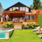 Casa de arriendo Orilla Lago Rapel con familia: niños saltando a la piscina, padres en reposeras, parrilla en la terraza